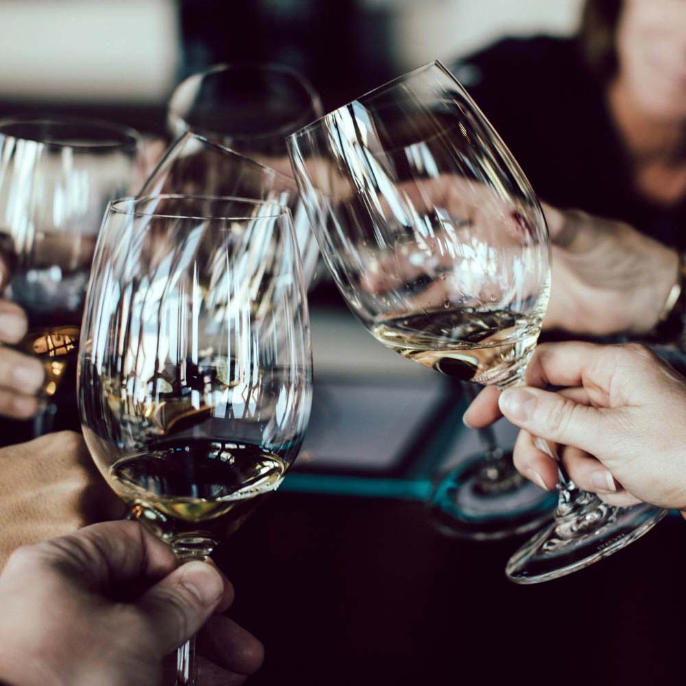 Cheersing wine glasses with white wine